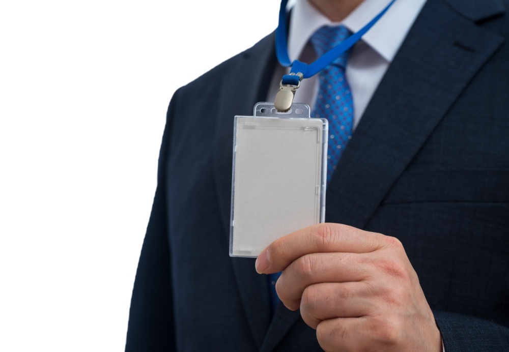 A person wears a lanyard around their neck with an ID card.